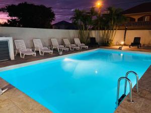 a swimming pool at night with lounge chairs and sidx sidx sidx sidx at LE NID TROPICAL in Étang-Salé les Bains