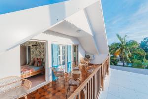 a balcony with a bed and a table and chairs at LE NID TROPICAL, Piscine chauffée in Étang-Salé les Bains +29 photos