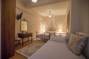 a bedroom with two beds and a table and a mirror at Ersis in Neochori