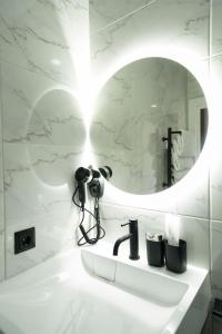 a bathroom with a mirror and a camera on a sink at MYFREEDOM Апартаменти метро Почайна, Оболонь in Kyiv