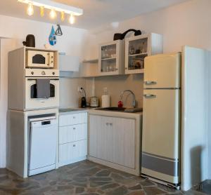 uma cozinha com electrodomésticos brancos e um frigorífico branco em Kythnos Beach house em Kythnos