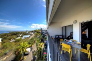 a balcony with a table and chairs and the ocean at L'appartement de l'Horizon - Plateau Cailloux in Fleurimont