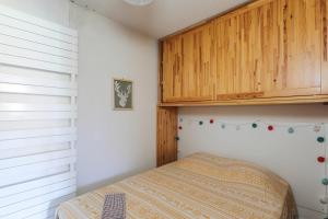 sypialnia z łóżkiem i drewnianą szafką w obiekcie Appartement des Bergers - Welkeys w mieście LʼHuez