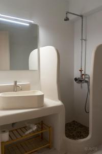 uma casa de banho com um lavatório branco e um espelho. em Kythnos Beach house em Kythnos