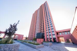 a tall red building with a courtyard in front of it at MYFREEDOM Апартаменти метро Почайна, Оболонь in Kyiv