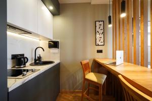 a kitchen with a counter with a sink and a chair at MYFREEDOM Апартаменти метро Почайна, Оболонь in Kyiv