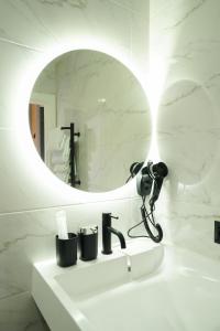 a bathroom with a mirror and a camera on a sink at MYFREEDOM Апартаменти метро Почайна, Оболонь in Kyiv