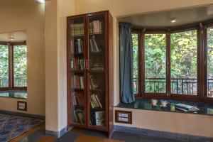 a library with bookshelves and windows at SaffronStays Alma Grove, Kashid in Kashid