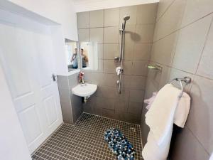 a bathroom with a sink and a mirror and a shower at Modern Victorian 4 bedroom home in trendy Observatory. in Cape Town