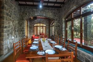 a dining room with a long table and chairs at SaffronStays Alma Grove, Kashid in Kashid