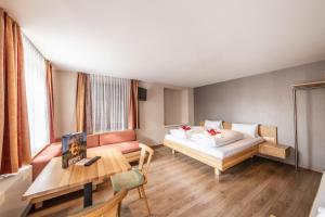 a hotel room with a bed and a table at Familienhotel Adler in Lingenau +53 photos