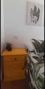 een slaapkamer met een bed en een nachtkastje met een plant bij Apartamento El Olivo in Villabáñez
