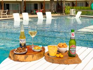 馬塞約的住宿－Salinas Maceio All Inclusive Resort，一张桌子,上面放有两瓶啤酒、食物和饮料