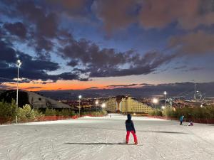 eine Person in roten Hosen, die auf einer Skipiste steht in der Unterkunft Polat Palandöken in Erzurum