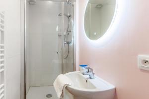 een witte badkamer met een wastafel en een douche bij Charming fisherman house in the center of Trouville - Welkeys in Trouville-sur-Mer