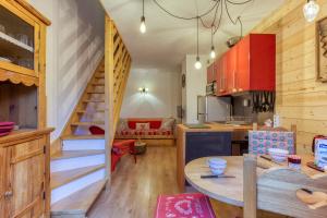 a kitchen with a table and a staircase in a room at Les Dolomites en Trièves in Gresse-en-Vercors