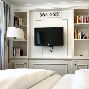 a bedroom with a tv on a wall with shelves at Hotel-Restaurant Anne-Sophie in Künzelsau