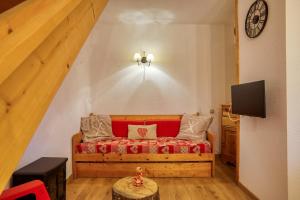 1 dormitorio con sofá rojo y TV en Les Dolomites en Trièves, en Gresse-en-Vercors