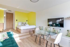 a room with a bed and a couch and a table at Brand new studio with sea view in the Deauville port - Welkeys in Deauville