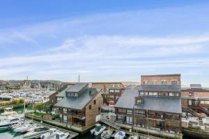 eine Gruppe von Gebäuden und Booten in einem Hafen in der Unterkunft Brand new studio with sea view in the Deauville port - Welkeys in Deauville