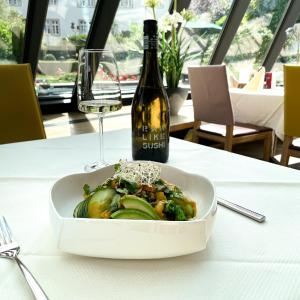 un plato de comida en una mesa con una botella de vino en Hotel-Restaurant Anne-Sophie, en Künzelsau