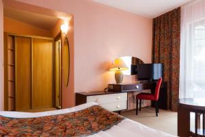 a hotel room with a bed and a desk and a television at To Tu in Mrągowo