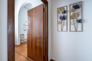um corredor com uma porta de madeira e duas imagens na parede em The Art Gallery em Florença