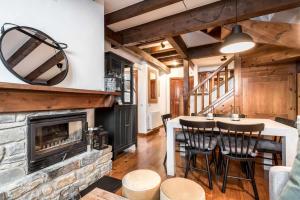 a kitchen and living room with a stone fireplace at Tanau 1700 by SeaMount Rentals in Naut Aran