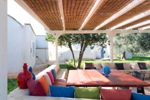 eine Terrasse mit einem Tisch und Stühlen unter einem Dach in der Unterkunft le dimore di MaMa in Ceglie Messapica