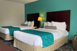 two beds in a hotel room with green walls at Travelodge by Wyndham Miramichi New Brunswick in Miramichi