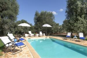 einen Pool mit Stühlen und Sonnenschirmen in der Unterkunft le dimore di MaMa in Ceglie Messapica