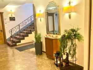 a hallway with a staircase with a mirror and a sink at Hotel Garni "Brauerei Keller" in Miltenberg