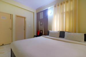 a bedroom with a large white bed with white pillows at FabExpress Buddha Residency in Patna