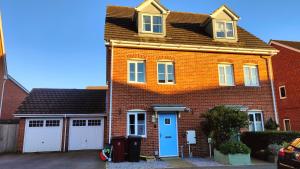 a red brick house with two white garage at Graylingwell! 4/5Bedroom House Chichester Goodwood in Chichester