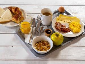 uma bandeja de comida de pequeno-almoço com ovos, bacon e torradas em ibis Paris Pantin Eglise em Pantin