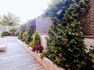 um jardim com plantas e flores num edifício em Chalet Familiar Jardín a 15 min centro y Warner em Rivas-Vaciamadrid