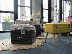 a living room with a yellow couch and a chair at ibis Paris Pantin Eglise in Pantin