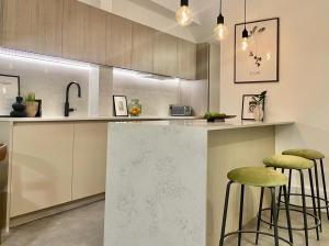 une cuisine avec deux tabourets de bar et un comptoir dans l'établissement 2 Bedroom Penthouse Apartment, à Londres
