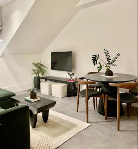 a living room with a table and a tv at 2 Bedroom Penthouse Apartment in London