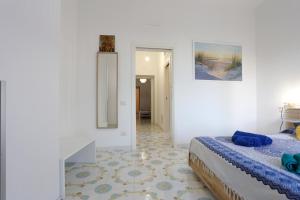 - une chambre blanche avec un lit et un couloir dans l'établissement Amazing Seaview Apartment with garden, à Vietri