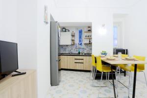 une cuisine et une salle à manger avec une table et des chaises jaunes dans l'établissement Amazing Seaview Apartment with garden, à Vietri
