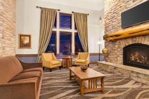 a living room with a fireplace and a tv at AmericInn by Wyndham Laramie Near University of Wyoming in Laramie