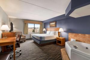Postel nebo postele na pokoji v ubytování AmericInn by Wyndham Laramie Near University of Wyoming + 37 fotografií