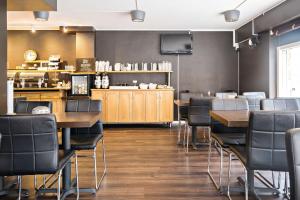 a restaurant with tables and chairs and a counter at Sure Hotel by Best Western Algen in Östersund