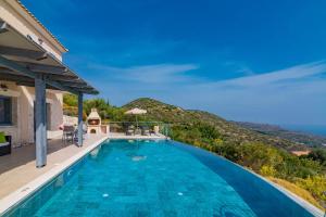 ein Schwimmbad mit einem Berg im Hintergrund in der Unterkunft Villa Pelagia Sea View by Villa Plus in Spathíon