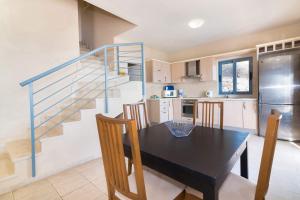 eine Küche und ein Esszimmer mit einem Tisch und einer Treppe in der Unterkunft Villa Pelagia Sea View by Villa Plus in Spathíon