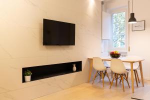 ein Wohnzimmer mit einem Tisch und einem TV an der Wand in der Unterkunft GoodVibesHome in Mailand