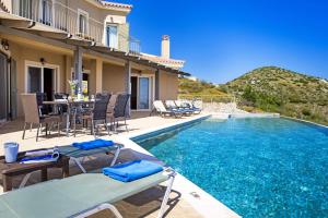 uma villa com uma piscina, uma mesa e cadeiras em Villa Agriada by Villa Plus em Spathíon