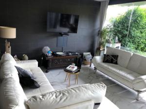 sala de estar con 2 sofás blancos y TV en Favoloso appartamento Roma con giardino, en Roma