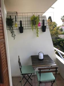 balcón con mesa de madera y 2 sillas en Design studio terrace and beach LIVE IN MARLYNE, en Cannes